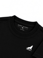 Close up of tonal black ribbed crew neckline, Kiddy Kloset neck label and white wolf logo