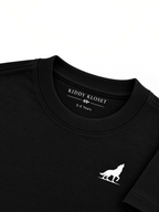 Close up of tonal black ribbed crew neckline, branded neck print and white wolf logo