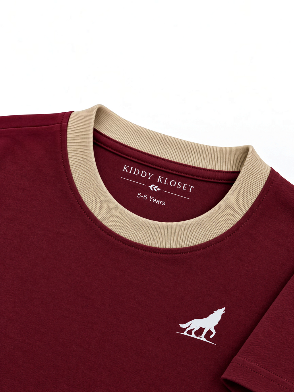 Close up of beige ribbed crew neckline, branded neck print and white wolf logo on burgundy tee