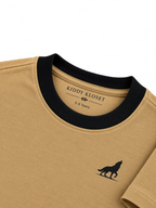 Close up of black ribbed crew neckline, branded neck print and black wolf logo on camel tee