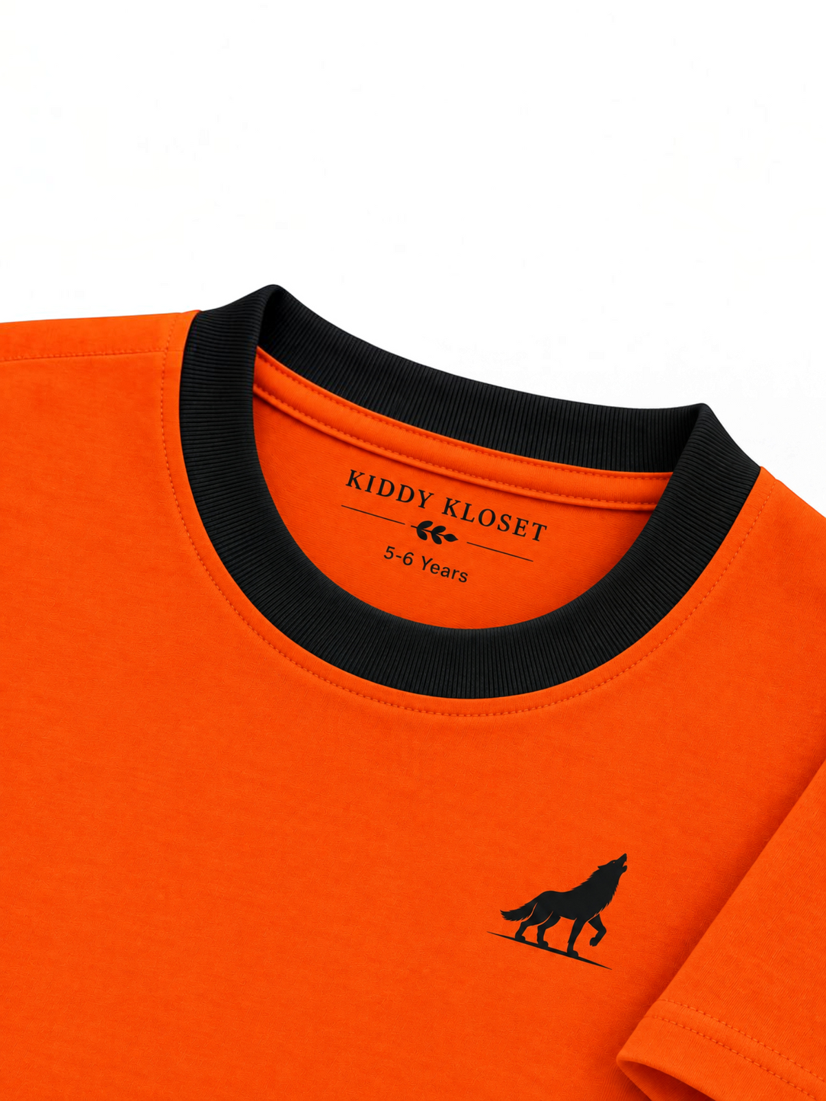 Close up of black ribbed crew neckline, branded neck print and black wolf logo on orange tee