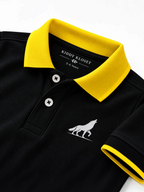 Close up of yellow polo collar, two-button placket and wolf logo on black kids polo shirt