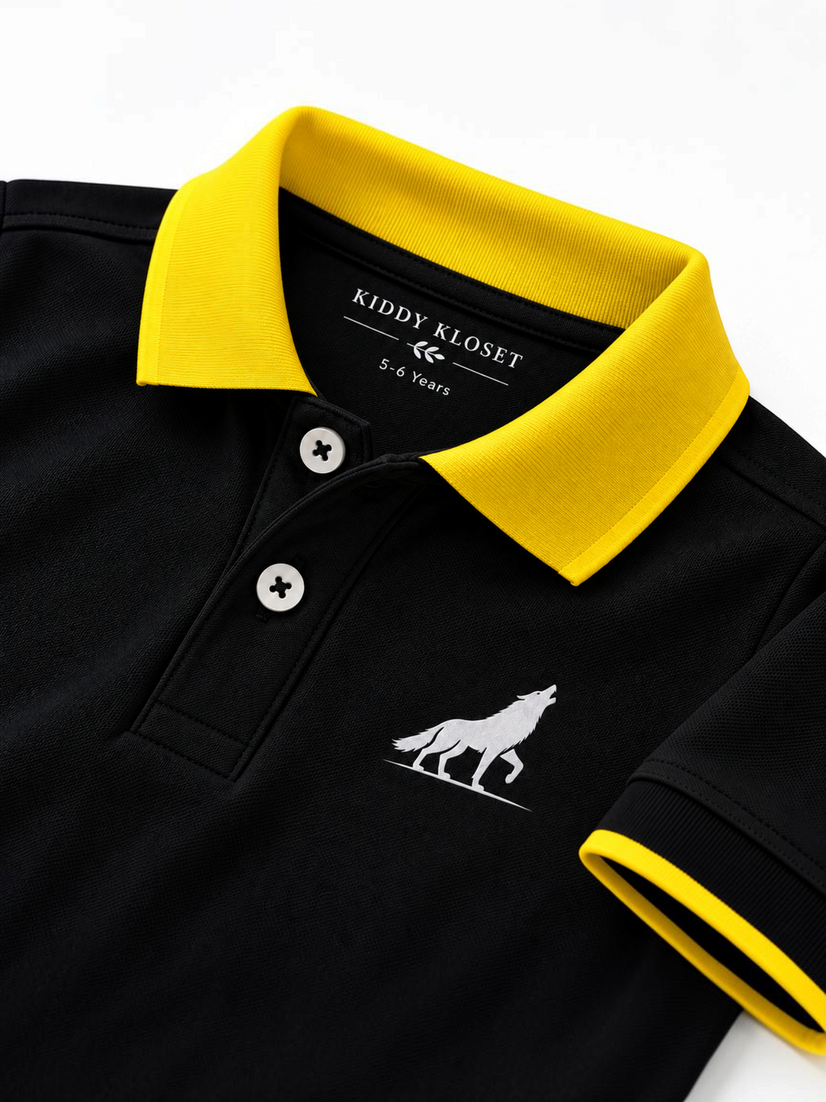 Close up of yellow polo collar, two-button placket and wolf logo on black kids polo shirt