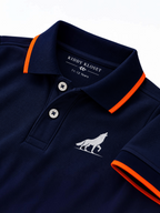 Close up of navy polo collar with orange tipping, two-button placket and wolf logo