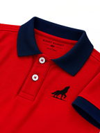 Close up of navy polo collar, two-button placket and wolf logo on red kids polo shirt