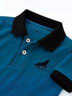 Close up of black polo collar, two-button placket and wolf logo on teal kids polo shirt