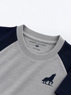 Close up of tonal grey ribbed crew neckline, branded neck label and navy wolf logo
