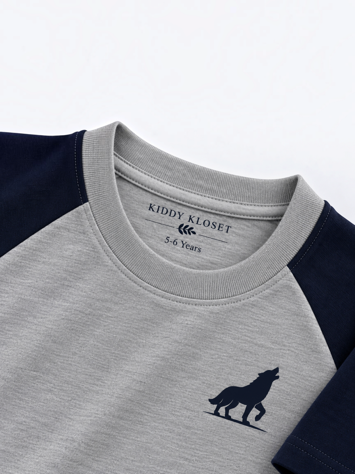 Close up of tonal grey ribbed crew neckline, branded neck label and navy wolf logo