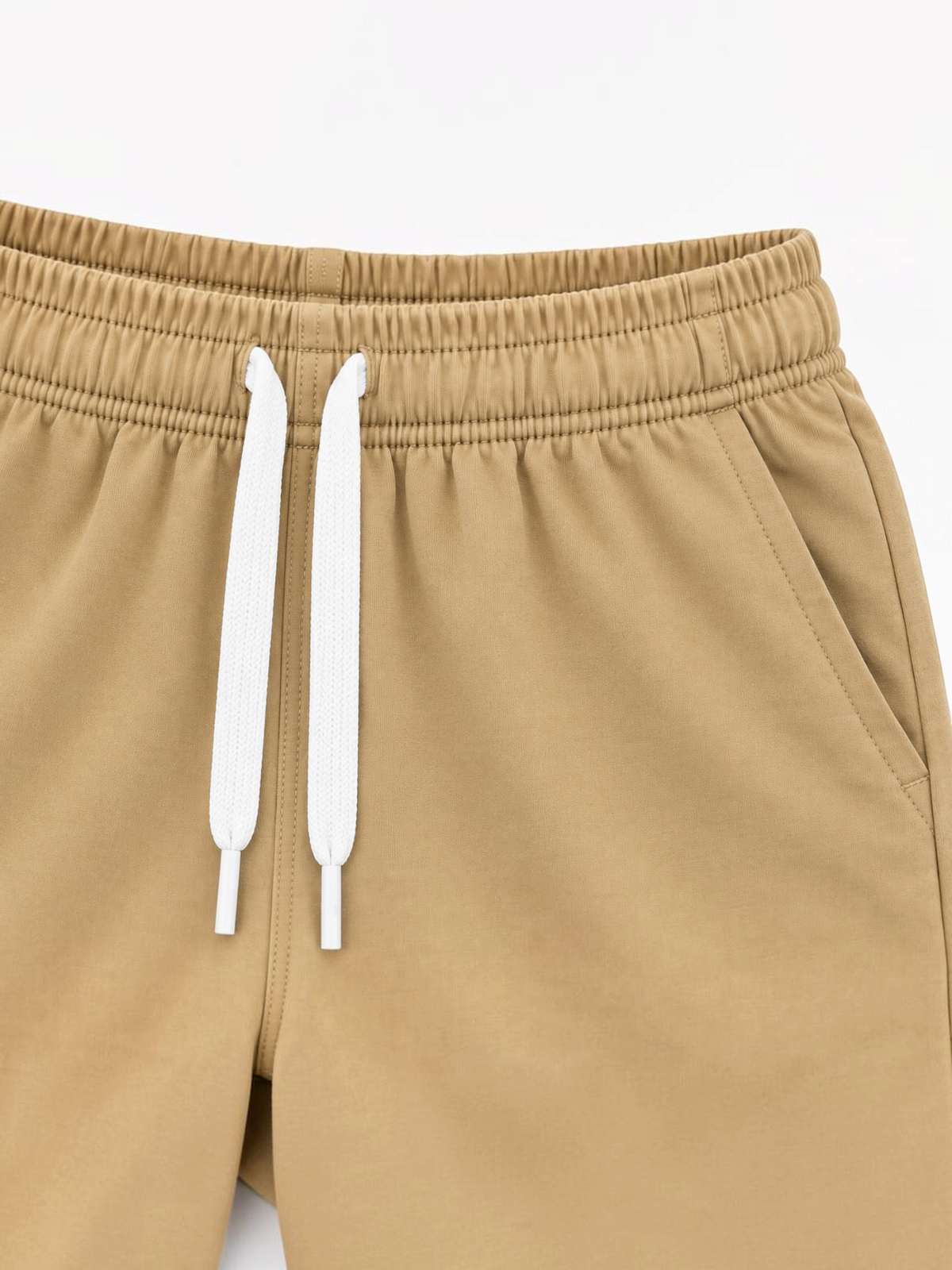 Close up of elasticated waistband, white drawcord and side pocket on kids camel brown shorts