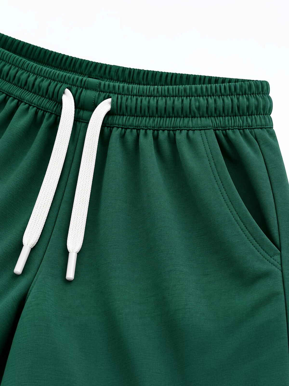 Close up of elasticated waistband, white drawcord and side pocket on kids forest green shorts